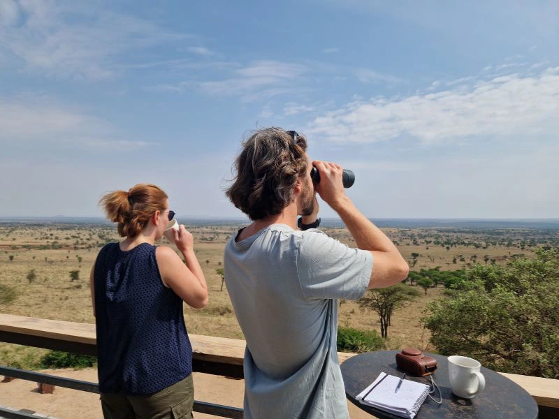 Reizigers genieten van het uitzicht over het Serengeti van hun terras.