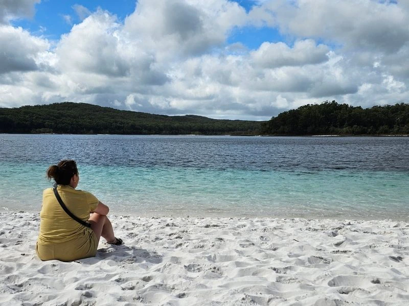 Vrouw zitten in het zand bij lake Mackenzie