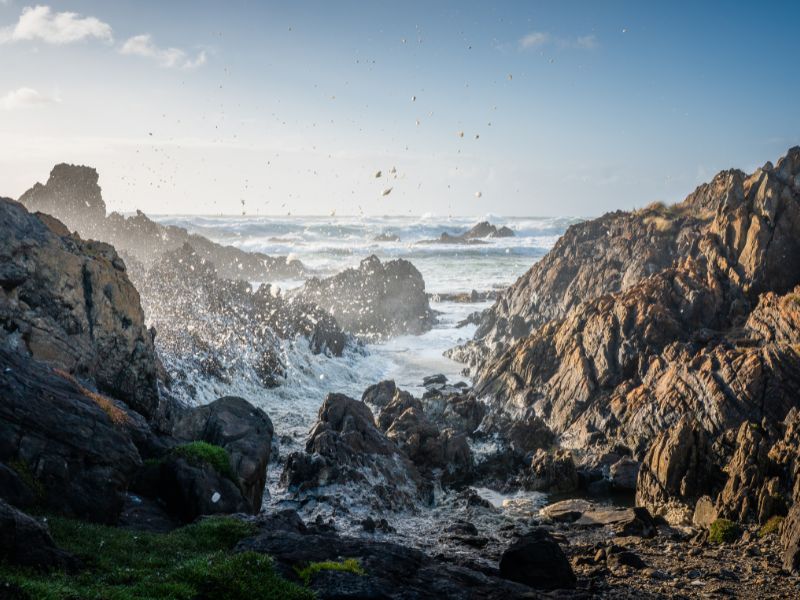 golven slaan tegen rotsen aan