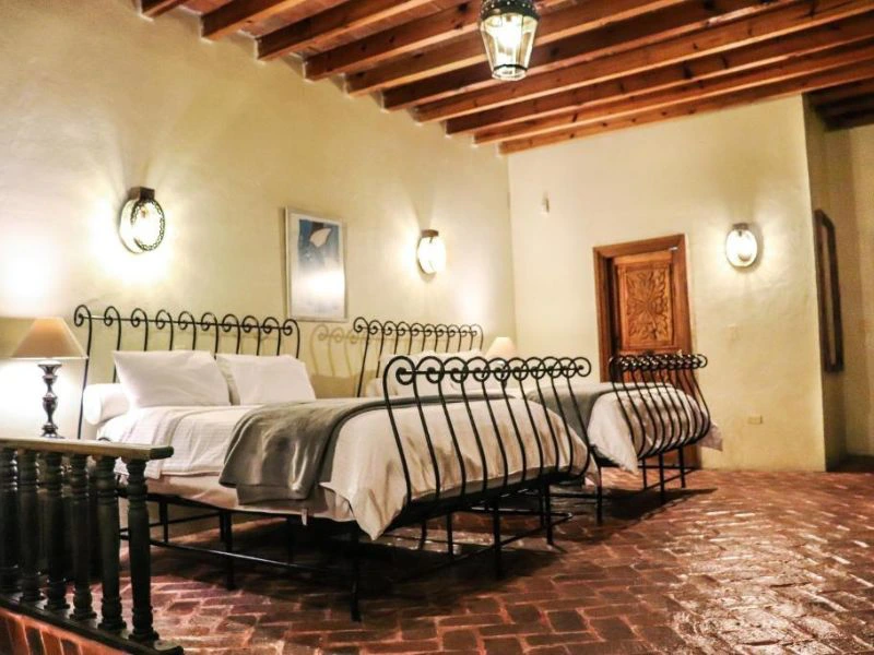 tweepersoonsbedden naast elkaar in authentieke kamer