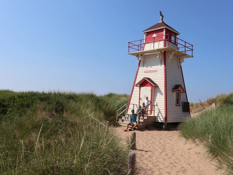 vader met kinderen bij vuurtoren op Prince Edward Island
