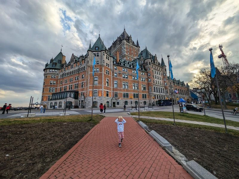 Meisje staat voor een gebouw in de stad Quebec.