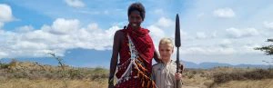 Jonge reiziger staat naast een Masai.