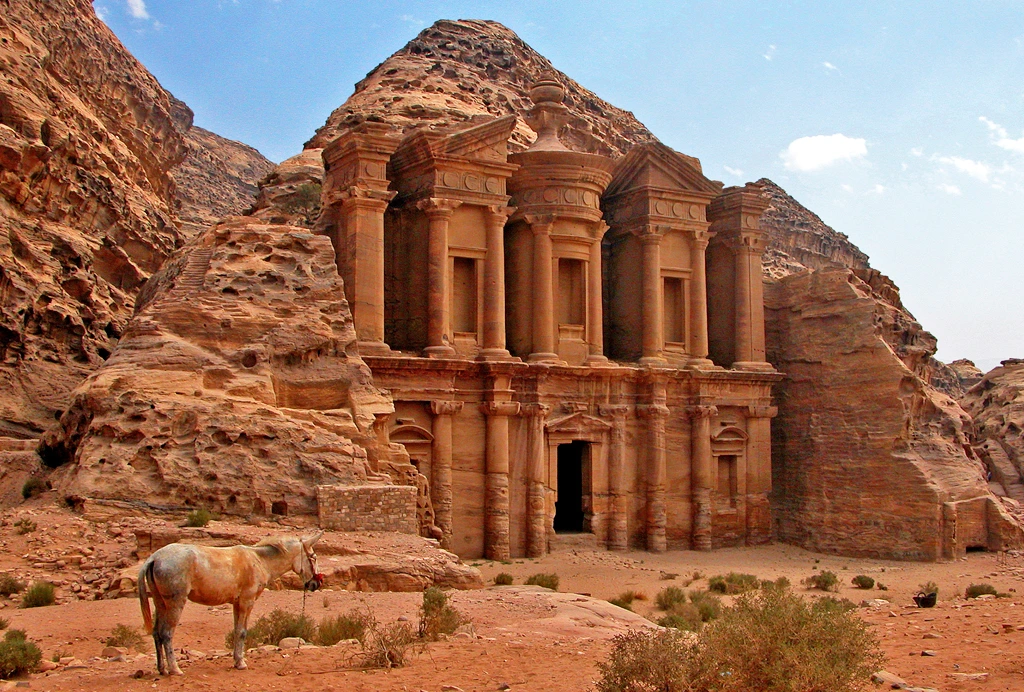 Oude rotsgevel van het klooster in Petra, Jordanië, met een paard op de voorgrond.