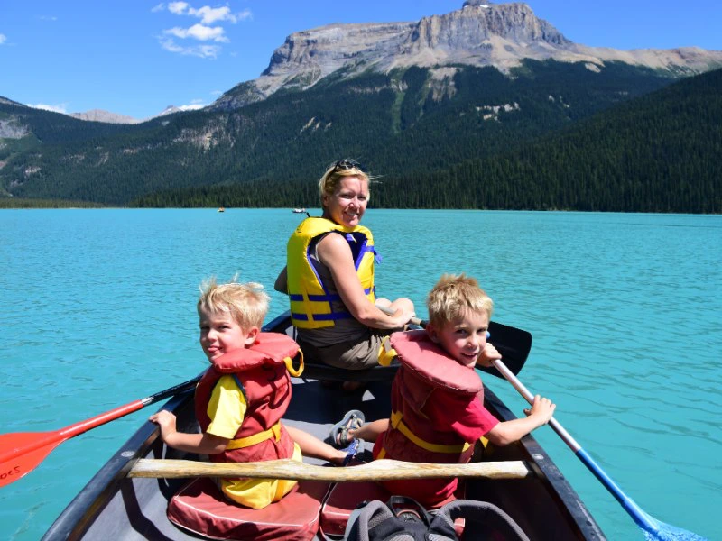 Familie kano op helderblauw meer in Canada
