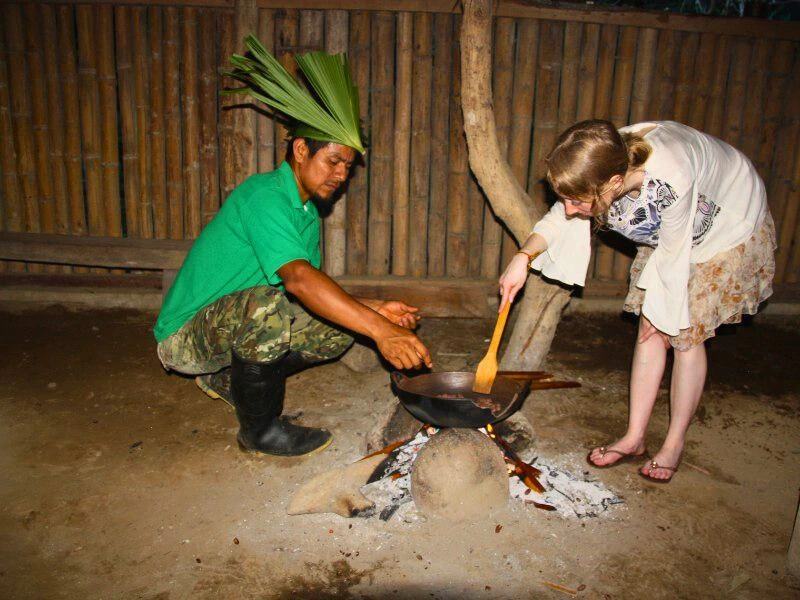 Ecuador Tena local making food with traveller