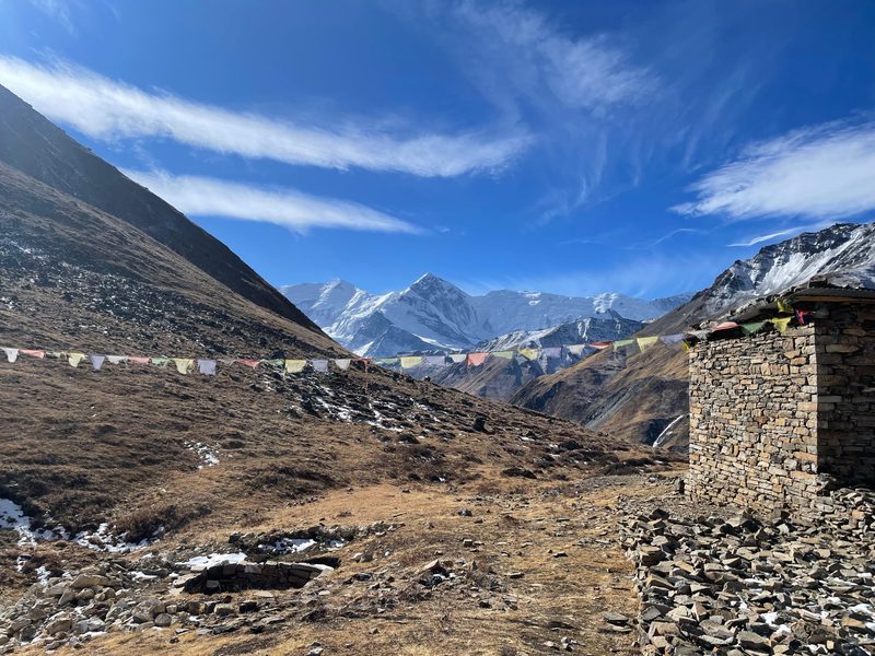 Uitzicht tijdens het Annapurna Circuit , met witte bergen op de achtergrond en Nepalese gebedsvlaggen