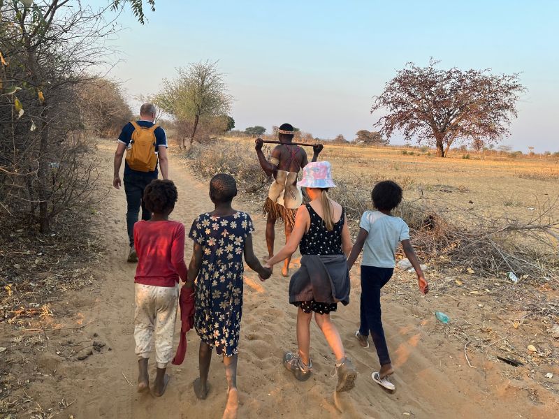 Himba kinderen lopen hand in hand met nederlands kind