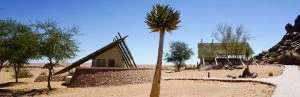 Midden in de woestijn met strak blauwe lucht staan enkele lodges.