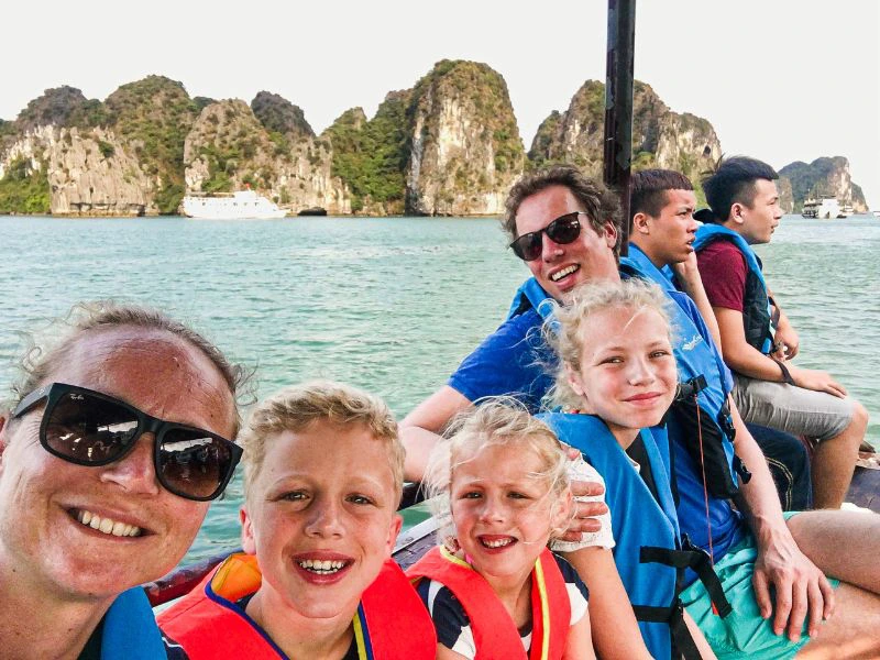 Familie aan boord van een boot met reddingsvesten aan.