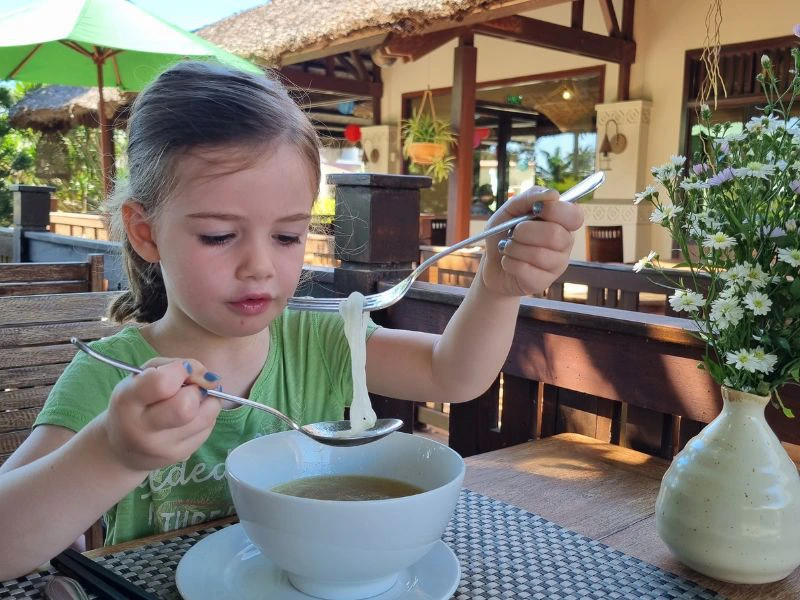 Meisje eet noedelsoep.