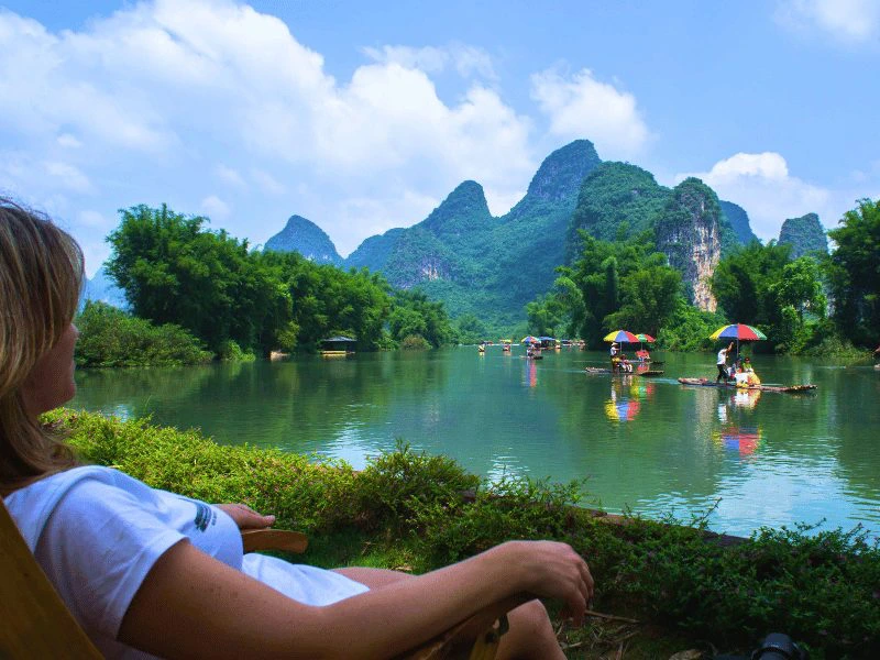 Vrouw geniet van het uitzicht over de karstbergen van Yangshuo