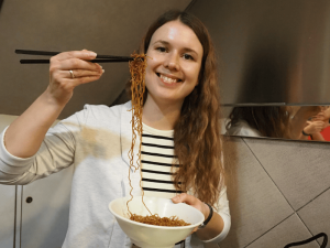 Vrouw eet noedels in Hong Kong