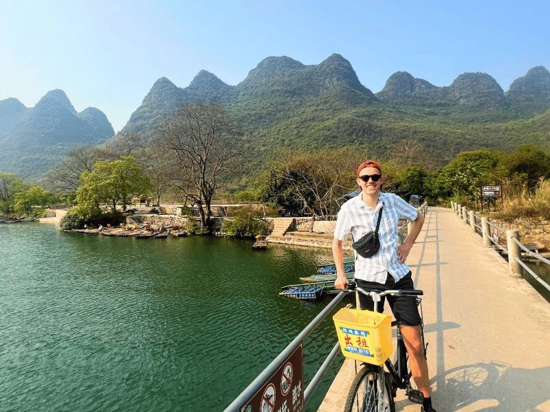 Reiziger op de fiets voor het karstgebergte in Yangshuo