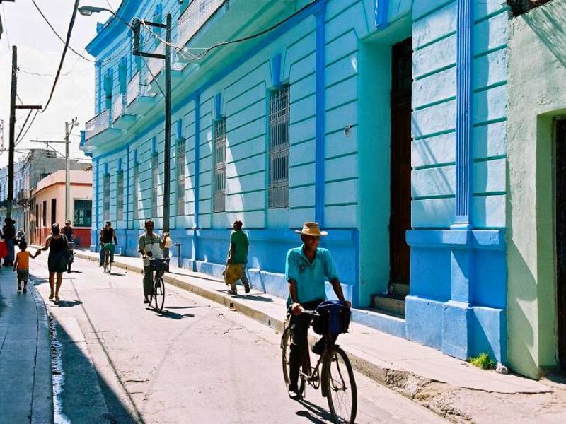 Cuba Camaguey centrum stad meneer op fiets langs gekleurde huisjes