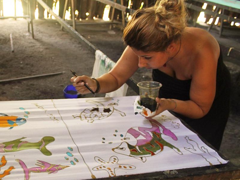 Vrouw is batik aan het schilderen tijdens een workshop