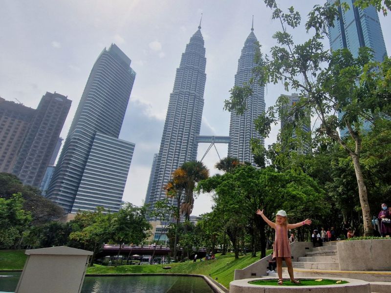Klein meisje poseert voor de petronas twin towers
