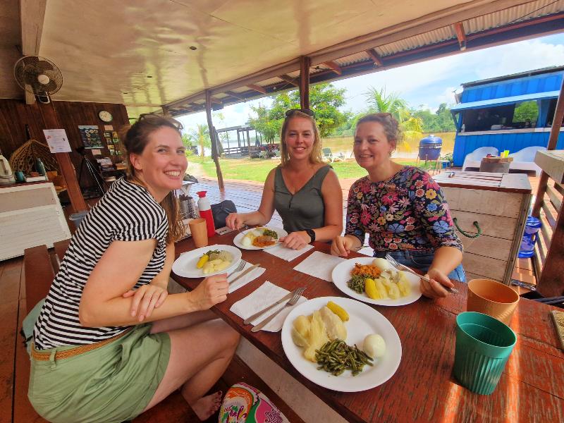 Reizigers in de algemene ruimte van de glamping met een surinaamse lunch