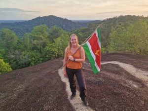 Reiziger op de top van de Fredberg met de surinaamse vlag