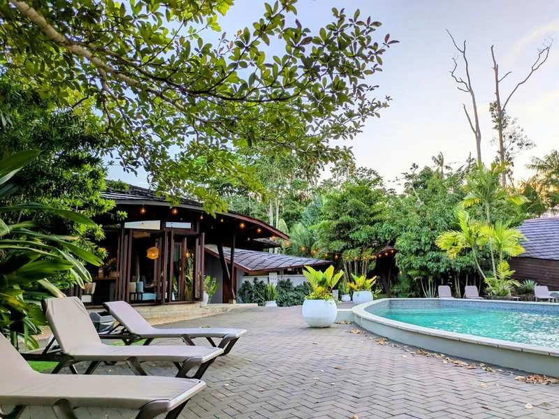 Het zwembad van het park met ligstoelen en een restaurant.