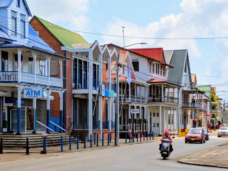 Winkelstraat in Paramaribo. Verschillende huizen in verschillende kleuren in de Surinaamse stijl