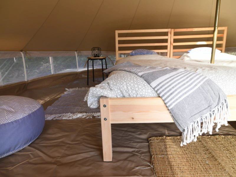 De binnenkant van de glampingtent met een tweepersoonsbed