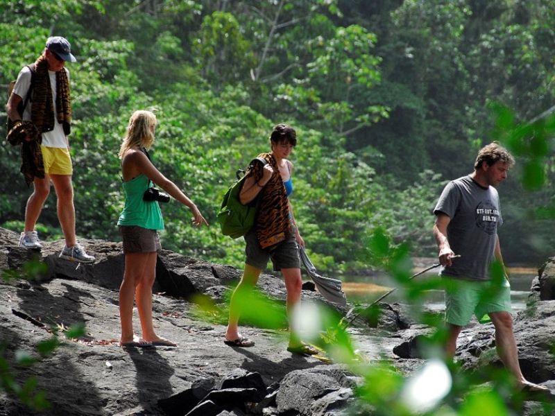 Reizigers wandelend over de rotsen bij de stroomversnelling