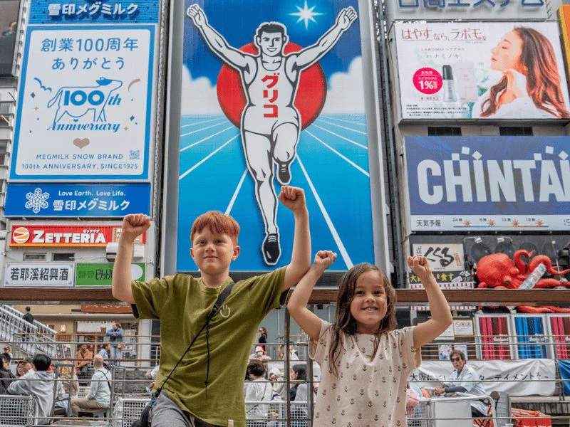 Kinderen voor neonreclames in Osaka
