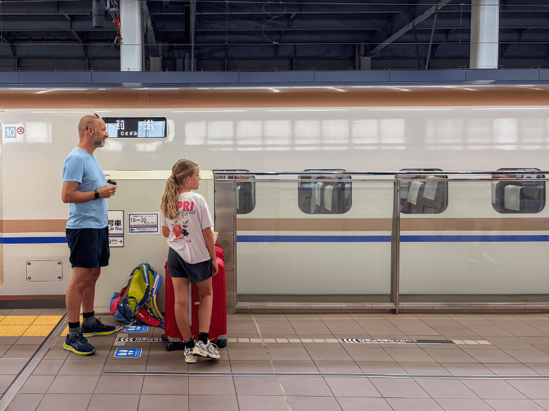 Vader en dochter op een treinstation in Japan.
