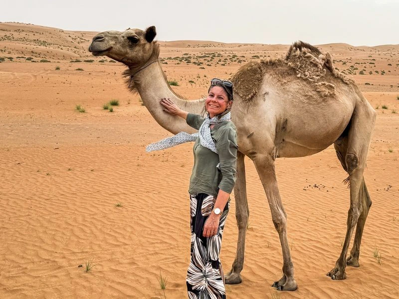 Reiziger en kameel in Wahiba Sands